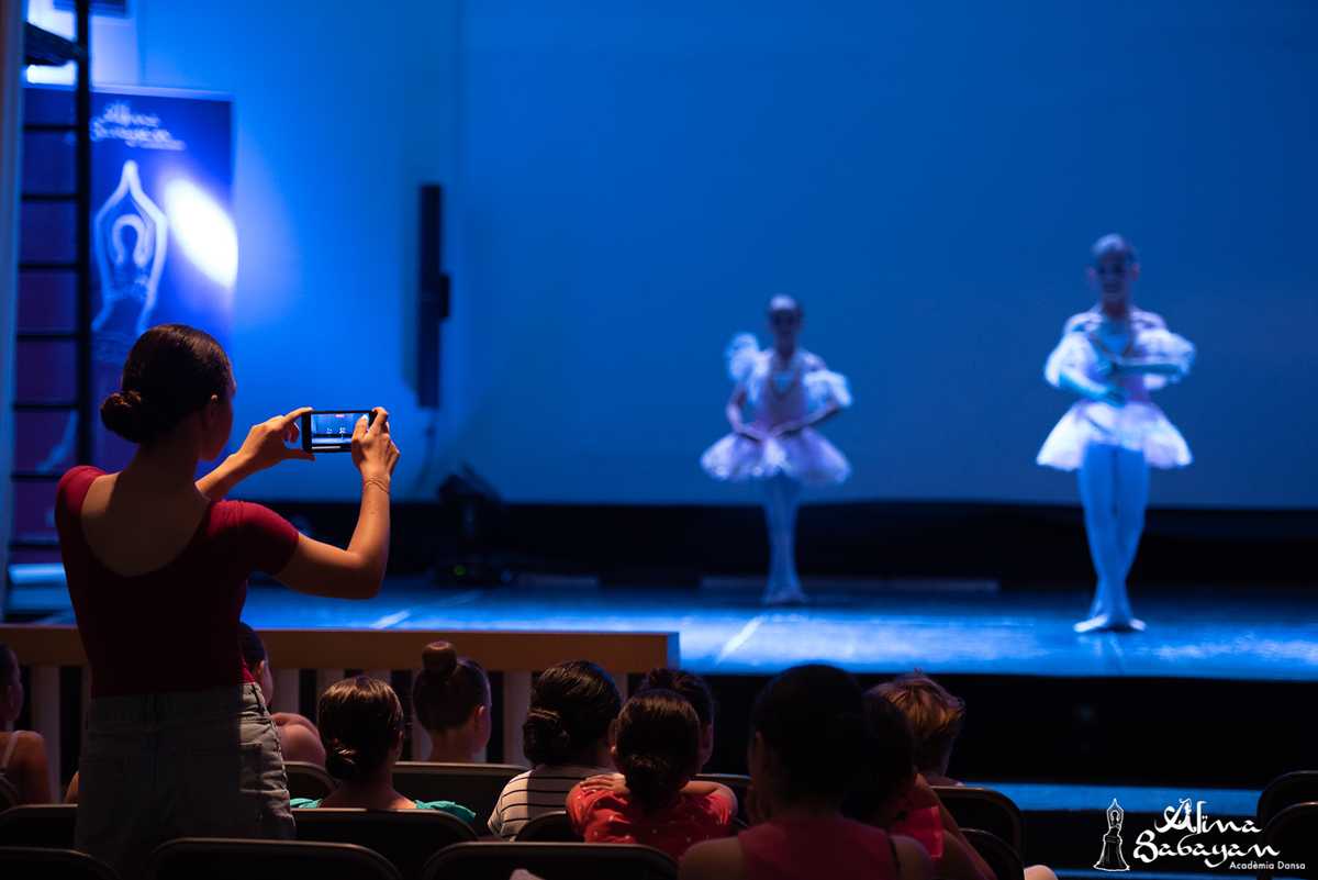 Alumnas de danza clásica infantil siendo fotografiadas en el escenario